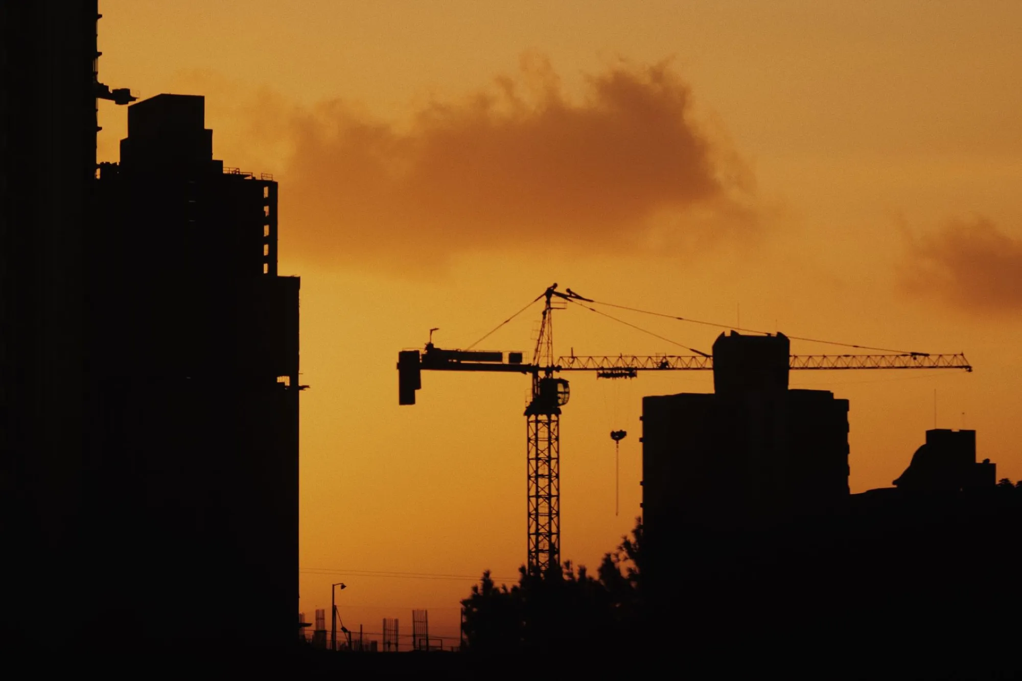 Construction crane silhouette at sunset